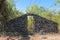 A boulder wall with open wooden doors. Stone wall by the road in Bali Island, Indonesia. Enter the jungle. Mystical place.