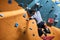 Boulderer with physical disability hanging at rock wall, balancing on one hand