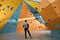 Boulderer with physical disability looking thoughtfully at colourful artificial walls