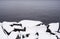 Boulders covered in snow by water.