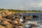 Boulders, forest, shore, evening light, sunset, clouds, blue sky and rainbow on the Baltic Sea