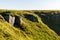 Boulders and rocks in the mountains. Carpathians. Summer, Autumn, Spring. The grass is influenced by the wind. Monument at the top