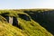 Boulders and rocks in the mountains. Carpathians. Summer, Autumn, Spring. The grass is influenced by the wind. Monument at the top