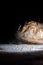 Boule or rustic loaf of french bread in motion on an old wooden table