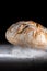 Boule or rustic loaf of french bread in motion on an old wooden table