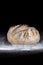 Boule or rustic loaf of french bread in motion on an old wooden table