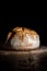 Boule or rustic loaf of french bread on an old wooden table