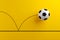 Bouncing football soccer ball on yellow background.