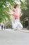 Bouncy and energetic. Energetic little child in motion on city street. Lively small girl jumping with energetic moves