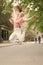 Bouncy and energetic. Energetic little child in motion on city street. Lively small girl jumping with energetic moves