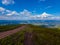 A boundless road in the mountains and quietly floating clouds above it in the sky