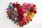 bouquet arranged in the shape of a heart, with red roses forming the core and various other colorful blooms