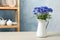 Bouquet of beautiful cornflowers in vase on white wooden table at home. Space for text