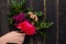 Bouquet of beautiful flowers for the holiday in a female hand on a wooden background