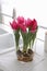 Bouquet of beautiful tulips with bulbs on countertop in kitchen