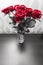 Bouquet of blossoming dark red roses in vase
