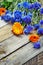 Bouquet of blue cornflowers and calendula on vintage wooden boar