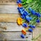 Bouquet of blue cornflowers and calendula on wooden board