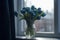 bouquet of blue tulips in a vase, a vase placed next to a window that illuminates the entire space