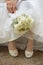 Bouquet of bride against dress and shoes