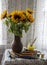A bouquet of bright sunflowers in a clay jug on the background of a lace curtain