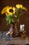 A bouquet of bright sunflowers in a clay jug, books, a glass of milk and a bowl of cookies