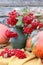 Bouquet of bright viburnum with ripe orange pumpkins, autumn still life, vertical frame