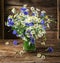 Bouquet of chamomiles and cornflowers in the vase.