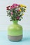 Bouquet of chrysanthemum flowers in green ceramic vase.