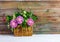 Bouquet of clover flowers, cornflowers and Jasmine in wicker basket on white wooden table on retro grunge background