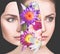Bouquet of colorful flowers inside young woman`s face.