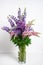 Bouquet of colorful lupines in a glass vase on white