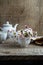 Bouquet of common daisies in tea cup, tea set on wooden table, rustic style