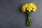 Bouquet of daffodils on dark background, top view with space for text.