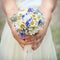 Bouquet of daisies in hands of bride
