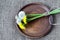 Bouquet of dandelions tied with twine on round clay brown dish. Rough homespun canvas, burlap of jute.