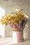 Bouquet of delicate dried hydrangea flowers and a lavender and lilac dried flowers in a pink hat box on a gray background.