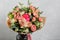 Bouquet of different flowers in a mixed arrangement against gray wall on background. Copy space