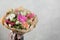 Bouquet of different flowers in a mixed arrangement against gray wall on background. Copy space