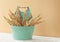 Bouquet of dried flowers spikelet in blue metal vase with handle on light beige background, comfort home decor minimalism style,
