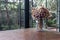 Bouquet of dried flowers in transparent glass vase on table at conservatory room