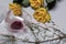 A bouquet of dried yellow roses and candle stubs. An overturned glass with sour wine and a spruce branch with fallen heads