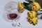 A bouquet of dried yellow roses. A glass of sour wine