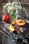 Bouquet of field daisies and ripe nectarines on vintage tray