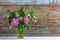 A bouquet of flowers of clover, cornflowers and Jasmine in a glass vase on a white wooden table on a retro grunge background