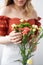 Bouquet of flowers in female hands. Beautiful chrysanthemum flowers bouquet in glass vase