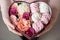 Bouquet of flowers and marshmallows in a gift box of heart in female hands.Congratulatory concept, sale.Close-up