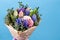 Bouquet of flowers with multi-colored hyacinths in craft paper package on a blue background. close-up, high quality