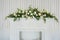 Bouquet of flowers over white fireplace in classic interior.