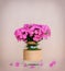 A bouquet of flowers Phlox in a homemade glass vase on pink background closeup